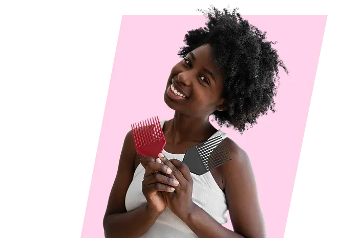 Coiffeuse afro souriante tenant un peigne, incarnant la mission de Ndeye Coiffure