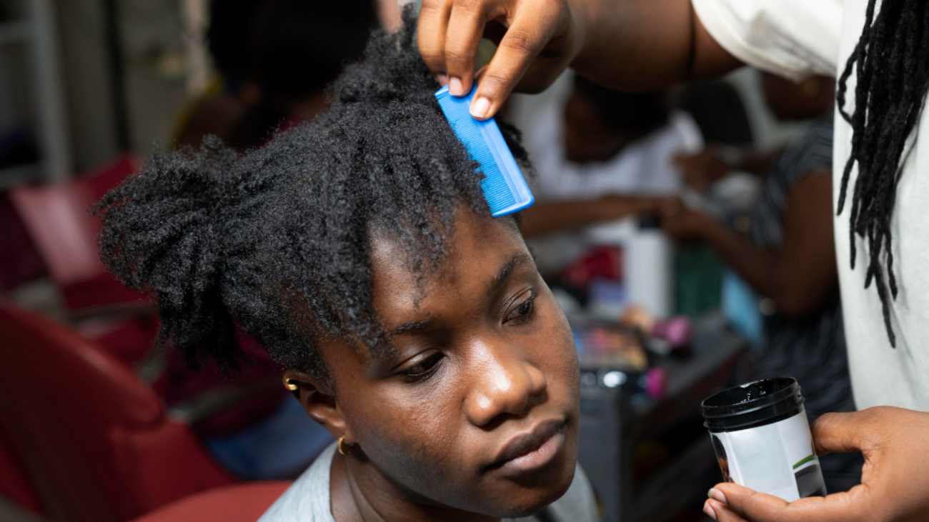 Jeune femme se faisant coiffer au salon de coiffure afro