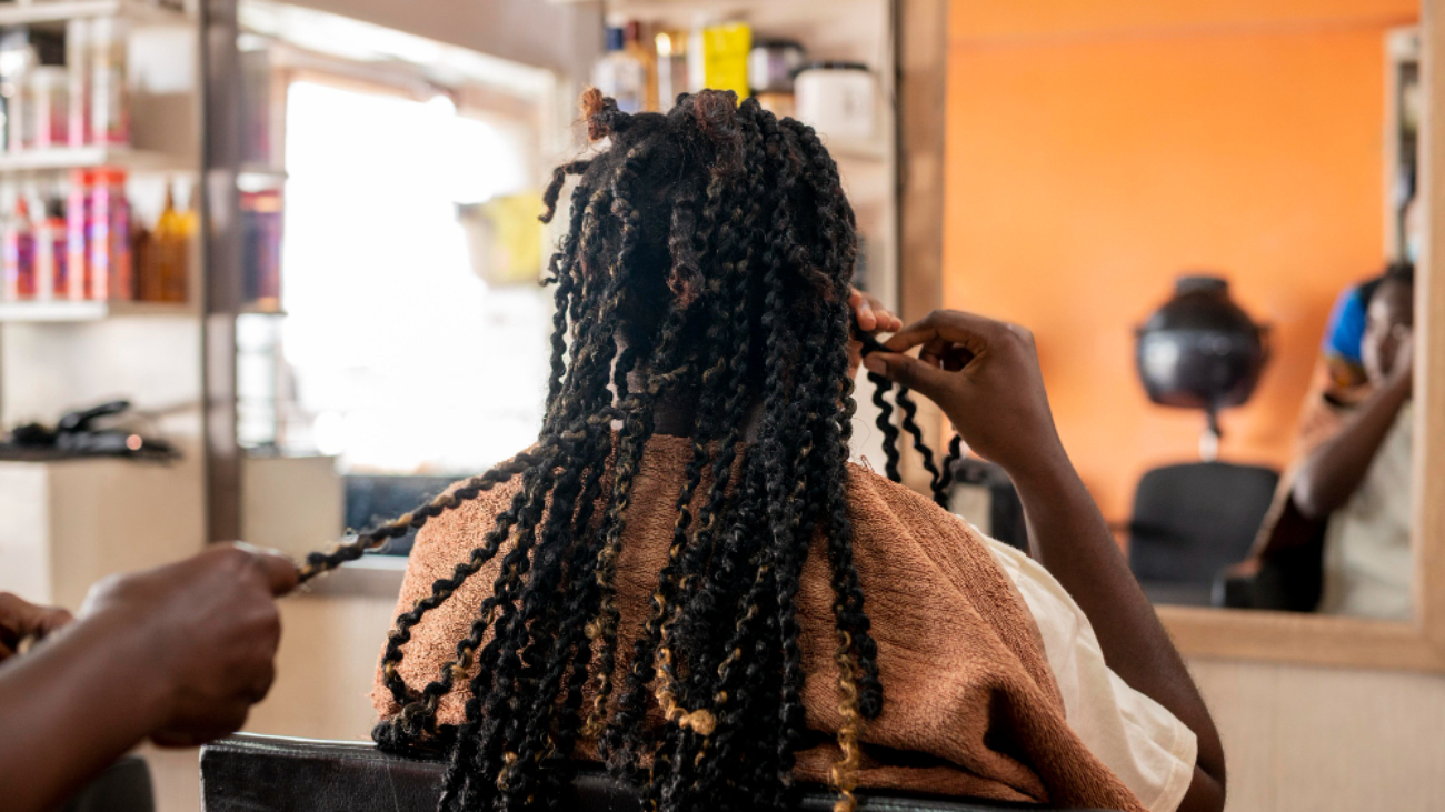 Belle femme se faisant coiffer au salon de coiffure afro