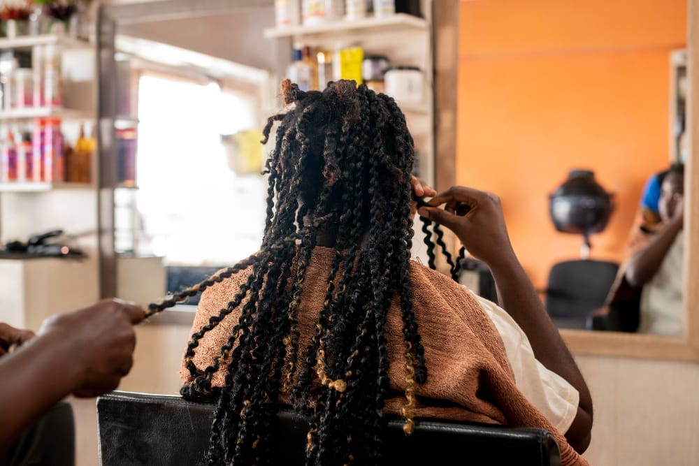 Belle femme se faisant coiffer au salon de coiffure afro