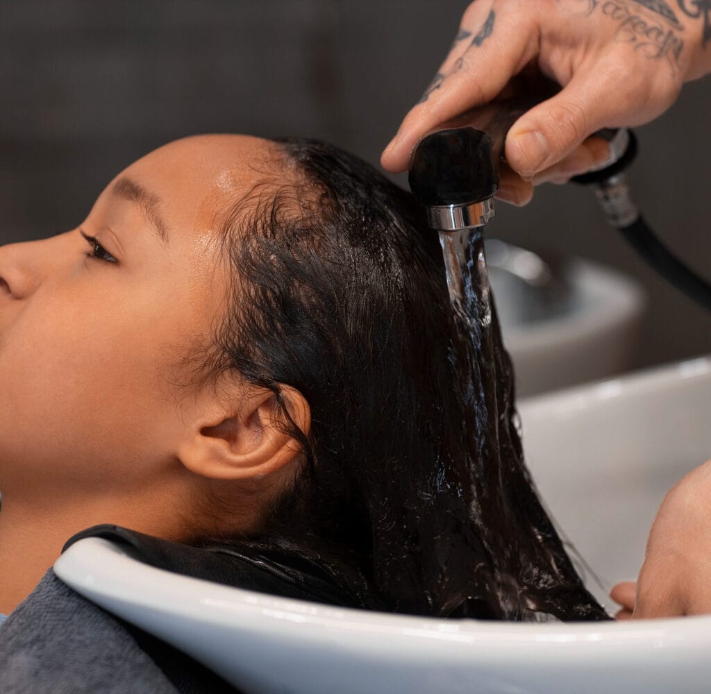 Enfant se faisant laver les cheveux au salon de coiffure